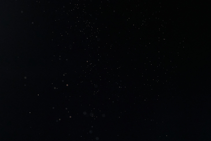 Tiny White Dust Particles on Black Background